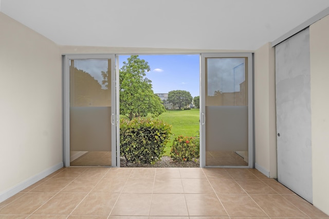 entryway featuring baseboards and light tile patterned flooring