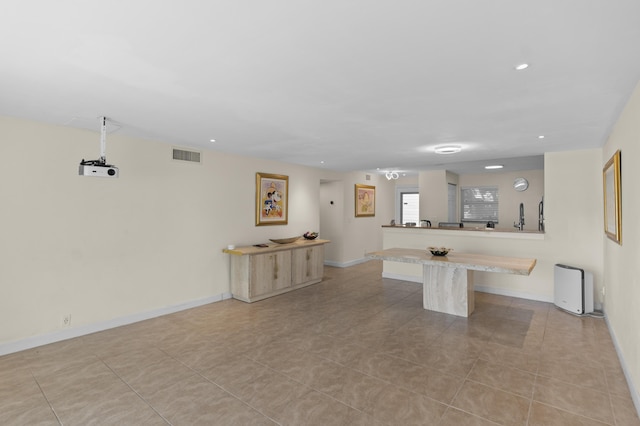 kitchen featuring a breakfast bar, recessed lighting, visible vents, a peninsula, and baseboards