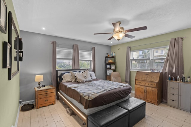 bedroom with light wood-style floors, multiple windows, and baseboards