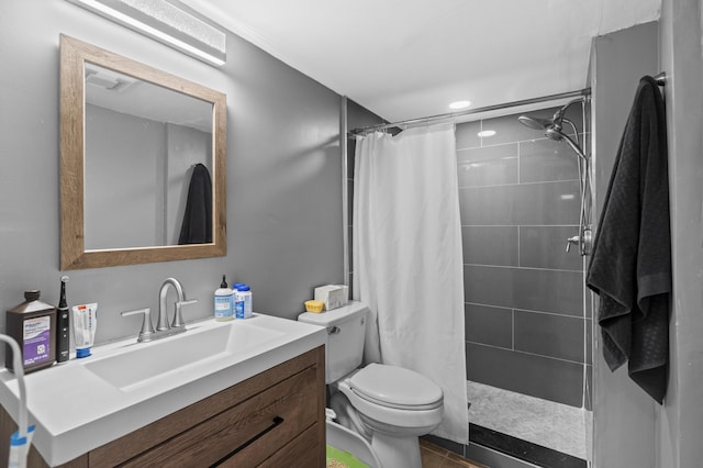 full bath featuring vanity, a tile shower, and toilet