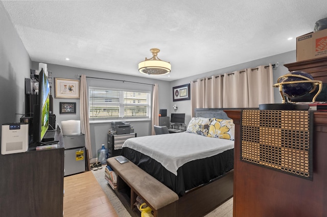 bedroom with light wood finished floors and a textured ceiling