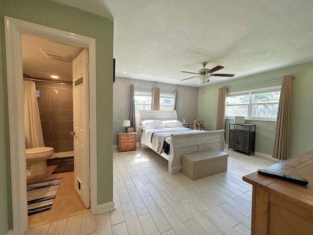 300 NE 26th Ave Unit 114, Boynton Beach, FL 33435 - bedroom featuring ceiling fan, a textured ceiling, light wood-style flooring, baseboards, and ensuite bathroom