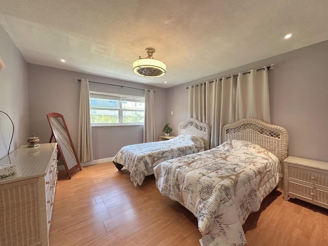 300 NE 26th Ave Unit 114, Boynton Beach, FL 33435 - bedroom featuring light wood-style floors, recessed lighting, a textured ceiling, and baseboards