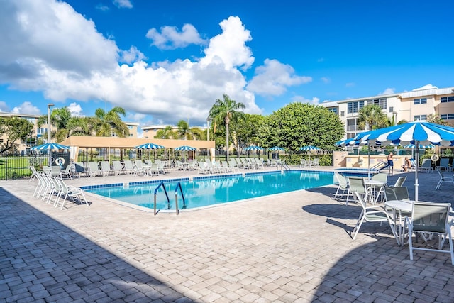 community pool with a patio and fence