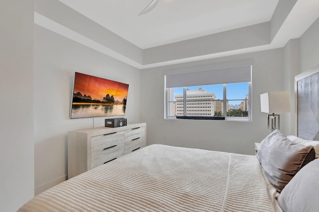 bedroom featuring ceiling fan and a raised ceiling