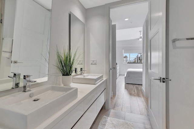 bathroom with wood-type flooring and dual bowl vanity