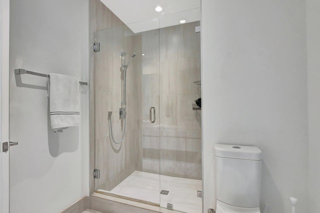 bathroom with an enclosed shower and toilet