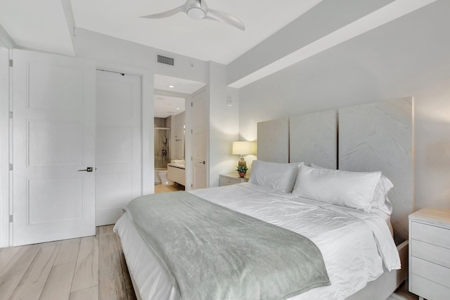 bedroom with hardwood / wood-style flooring, connected bathroom, and ceiling fan