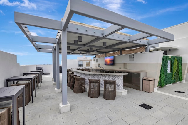 view of patio featuring exterior bar and a pergola