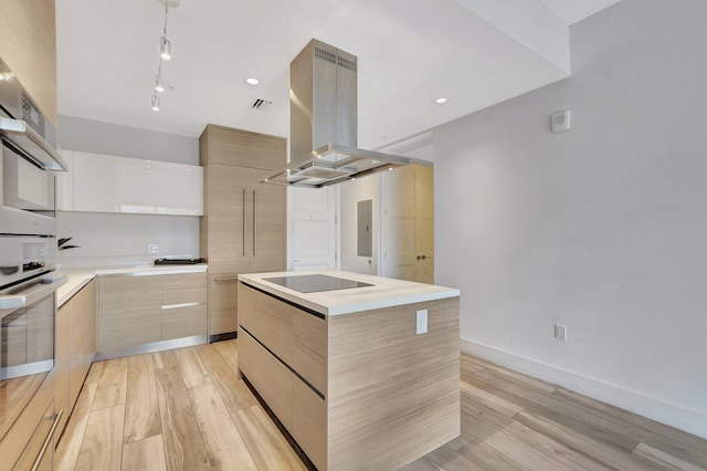 kitchen with black electric cooktop, rail lighting, light wood-type flooring, a kitchen island, and island range hood