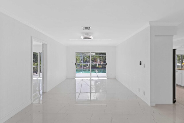 unfurnished room with crown molding and a healthy amount of sunlight