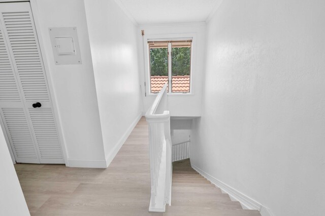 stairway with hardwood / wood-style floors and crown molding