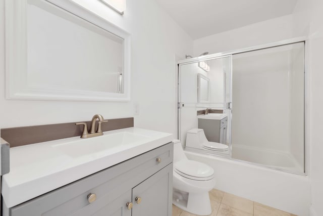 full bathroom featuring vanity, shower / bath combination with glass door, tile patterned floors, and toilet