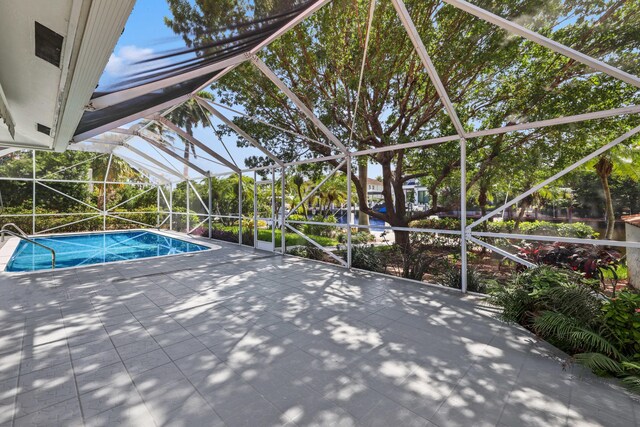 view of pool featuring glass enclosure and a patio area