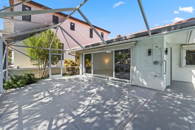 rear view of house with a patio area and glass enclosure