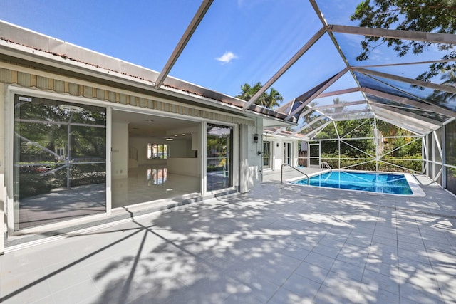 view of pool featuring glass enclosure and a patio