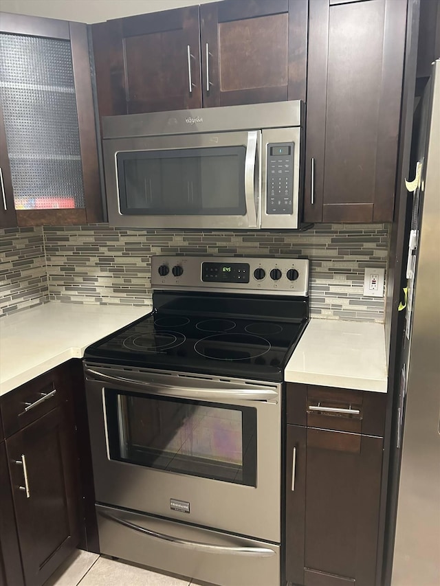 kitchen featuring appliances with stainless steel finishes, dark brown cabinets, and backsplash