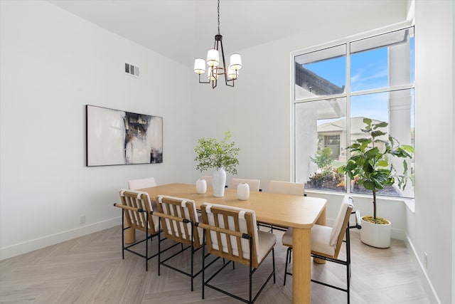 dining area featuring light parquet flooring, a wealth of natural light, and a chandelier