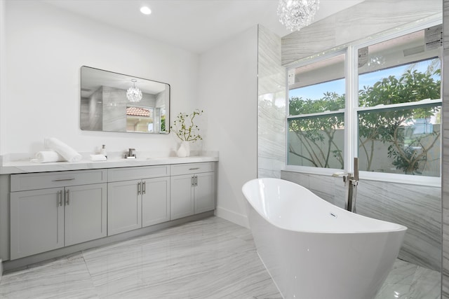 bathroom featuring a healthy amount of sunlight, vanity, tile patterned floors, and a tub