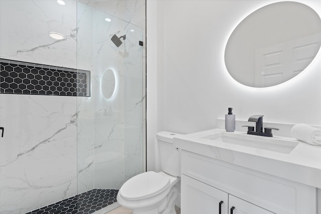 bathroom with tiled shower, toilet, and vanity