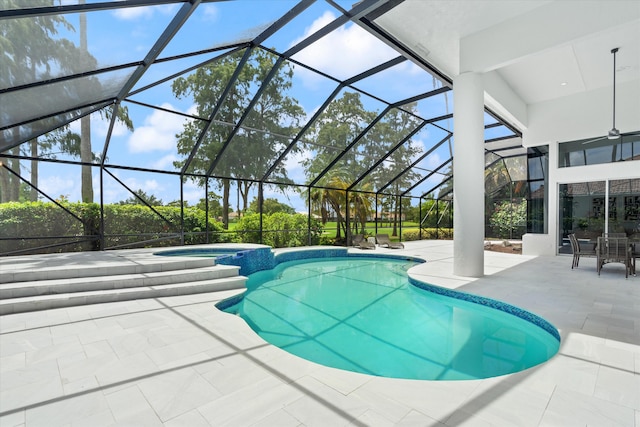 view of pool with glass enclosure, a patio, and an in ground hot tub