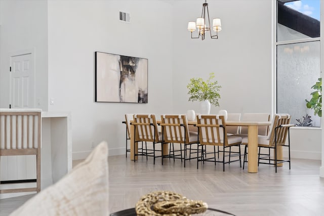 dining area with light parquet flooring and a notable chandelier