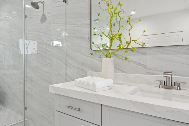 bathroom with vanity, tile walls, and a shower with shower door