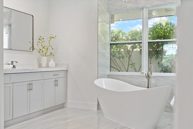 bathroom with tile patterned floors, tile walls, a bathing tub, and vanity