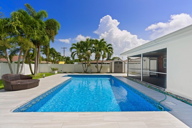 view of pool featuring a patio and a storage unit