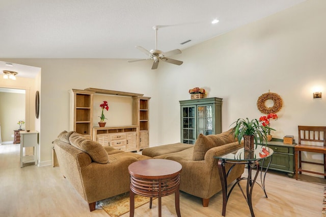 living room featuring vaulted ceiling, ceiling fan, and light wood-type flooring