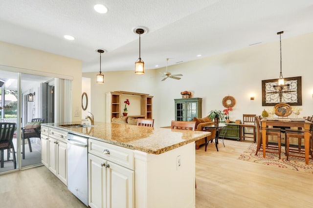 kitchen with pendant lighting, light stone countertops, stainless steel dishwasher, and white cabinets