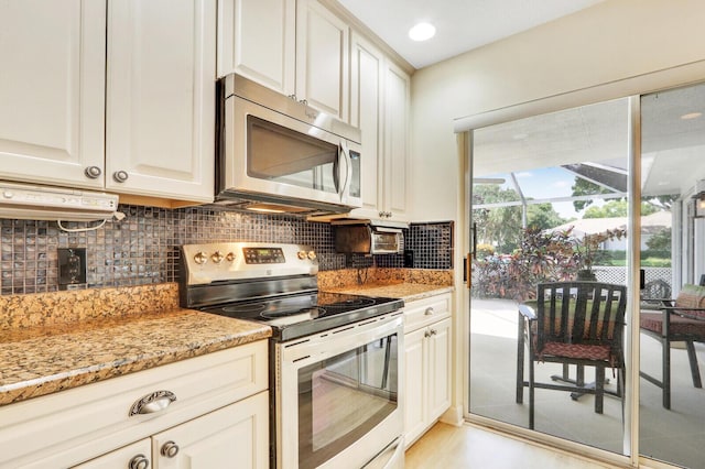 kitchen featuring tasteful backsplash, stainless steel appliances, light stone countertops, and white cabinets