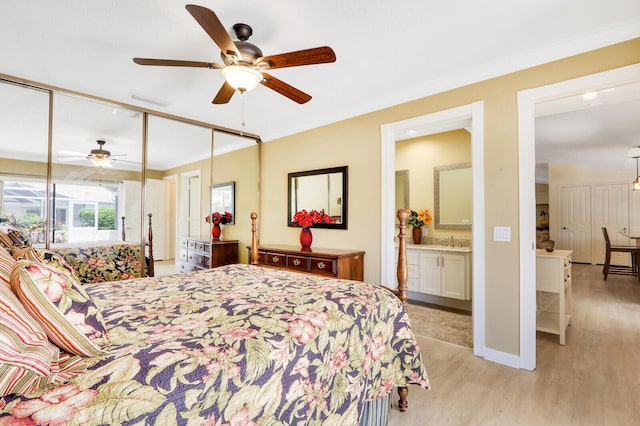 bedroom with sink, light hardwood / wood-style flooring, ornamental molding, ceiling fan, and a closet