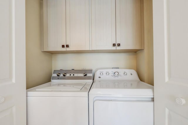 washroom featuring cabinets and washing machine and clothes dryer