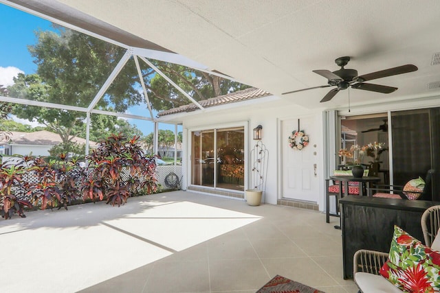 view of patio with ceiling fan and glass enclosure