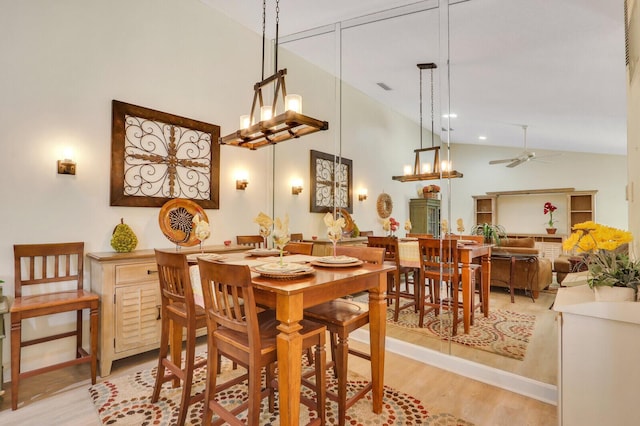 dining room featuring ceiling fan, high vaulted ceiling, and light hardwood / wood-style flooring