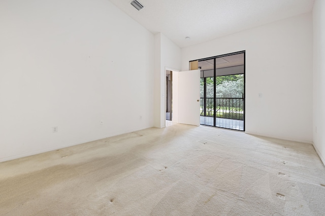 carpeted empty room with high vaulted ceiling