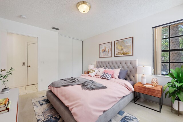 bedroom with a textured ceiling and light tile patterned floors