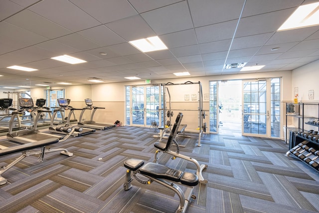 gym with carpet flooring, a paneled ceiling, and plenty of natural light