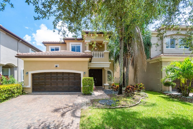 mediterranean / spanish-style home featuring a balcony, a garage, and a front yard