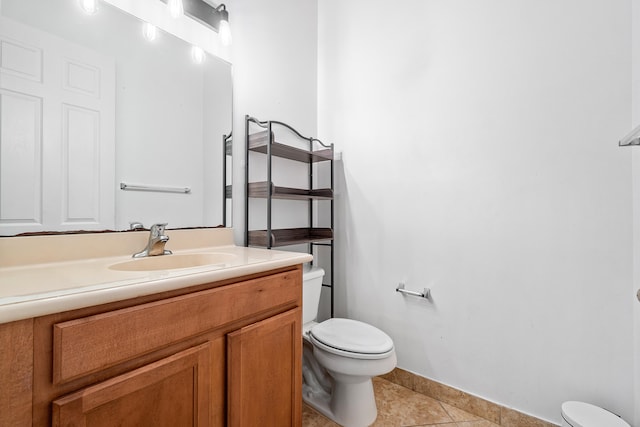 bathroom with vanity, tile patterned flooring, and toilet