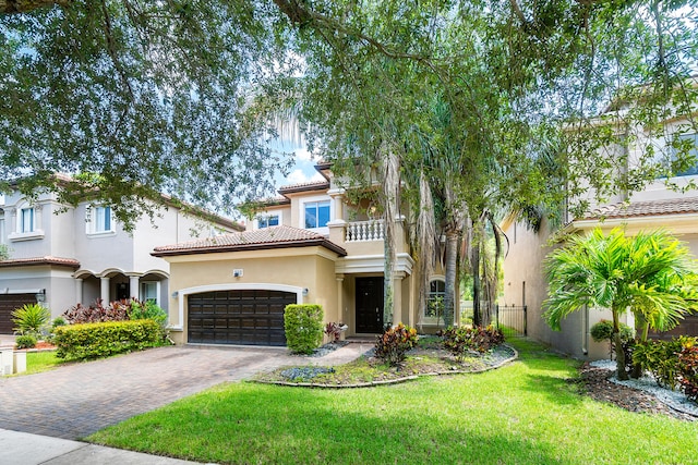 mediterranean / spanish house with a balcony, a garage, and a front yard