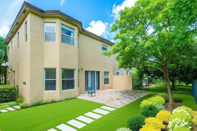 back of property with a patio and a lawn