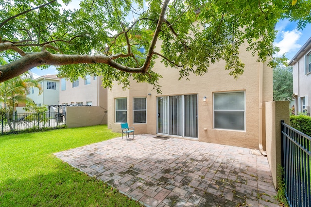 back of property featuring a yard and a patio area