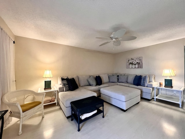 living room featuring ceiling fan and a textured ceiling