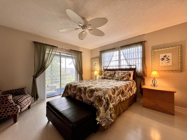 bedroom featuring access to outside, ceiling fan, multiple windows, and a textured ceiling