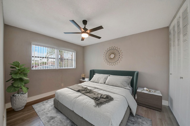 bedroom with wood-type flooring, a closet, and ceiling fan