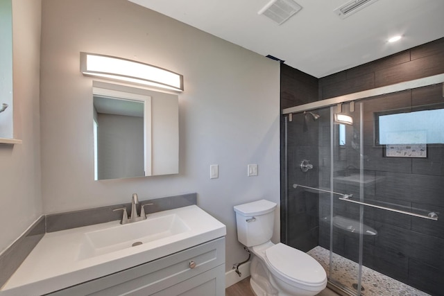 bathroom with an enclosed shower, vanity, toilet, and hardwood / wood-style floors