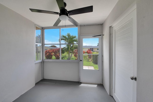 unfurnished sunroom featuring ceiling fan