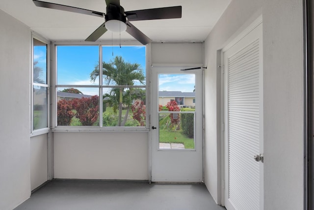 unfurnished sunroom featuring ceiling fan